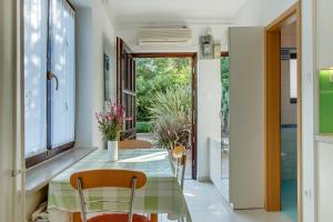 a dining room with a green table and chairs at Apartment Simona in Mali Lošinj