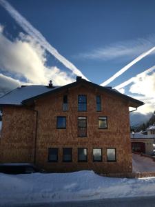 un edificio de ladrillo con nieve delante en DAV-Haus (Alpenverein), en Obertauern