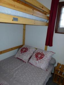 een bed met twee kussens in een kamer bij SOLEIL BLANC C27 in Montriond