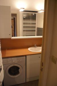een badkamer met een wastafel en een wasmachine bij SOLEIL BLANC C27 in Montriond