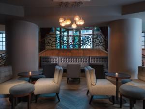 a restaurant with tables and chairs and a staircase at Malmaison Hotel Leeds in Leeds