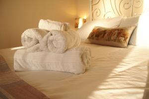 a pile of towels sitting on top of a bed at Brinsley Barn in Blagdon