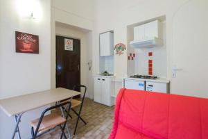 una cucina con tavolo e un divano rosso in una camera di Location Turistic by Heart of Asti CIR 00032 ad Asti