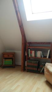 a attic room with a book shelf and a skylight at Gîte La Cavée in Le Bourg-Dun