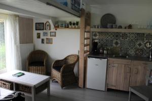 una cucina con frigorifero bianco e sedie in vimini di Bed and Stay Amsterdam ad Amsterdam