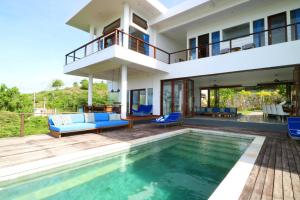 a villa with a swimming pool and a house at Villa Nambung in Selong Belanak