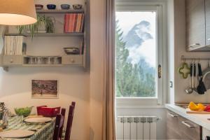 a kitchen with a table and a window at Casa Nia in Madonna di Campiglio