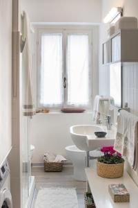 a white bathroom with a sink and a toilet at Casa Nia in Madonna di Campiglio