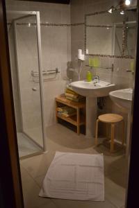 a white bathroom with a sink and a shower at Chambres d'Hôtes S'burehiesel in Schillersdorf +19 photos