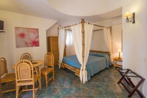 - une chambre avec un lit, une table et des chaises dans l'établissement Luna di Ponente, à Lampedusa
