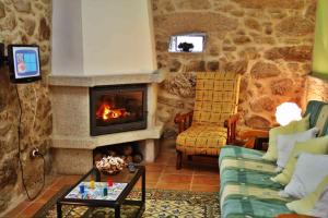 sala de estar con chimenea en una pared de piedra en Casa Dolores Mato, en Laxe
