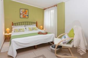 a bedroom with a large bed and a chair at Apartments Mario in Pula
