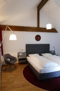 ein Schlafzimmer mit einem Bett, einem Stuhl und einer Lampe in der Unterkunft Hotel Ottheinrich in Weinheim