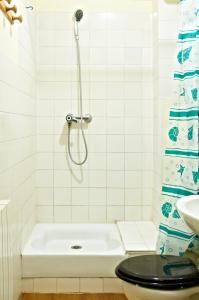 y baño con ducha, aseo y lavamanos. en Hotel Luxor, en Issy-les-Moulineaux