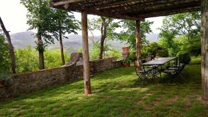 uma mesa de piquenique num quintal com uma parede de pedra em Casa Chiara by VacaVilla em Preggio