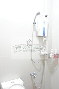 a bathroom with a toilet and a sign that reads the guest house at The Guest House in Lucena