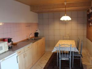 a kitchen with a table and chairs in it at Cheerful Apartment in Brusow with Terrace, Garden and Barbecue in Kröpelin