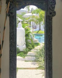 a mirror with a view of a pool in a house at Harmony Villas in Kuta Lombok