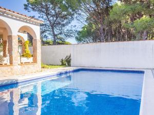 una piscina frente a una valla blanca en Belvilla by OYO La Caleta en L'Escala