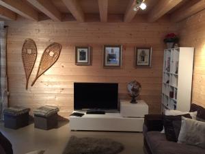 サン・ジャン・ドルプにあるChalet Serinの木製の壁に薄型テレビ付きのリビングルーム