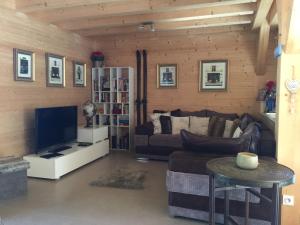 a living room with a couch and a tv at Chalet Serin in Saint-Jean-d'Aulps +32 photos