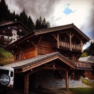 una grande casa in legno con un balcone sopra di Chalet Serin a Saint-Jean-d'Aulps