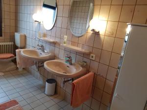 ein Badezimmer mit zwei Waschbecken und zwei Spiegeln in der Unterkunft Ferienwohnung Rosita in Langgöns