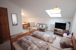 ein Wohnzimmer mit 2 Betten und einem Flachbild-TV in der Unterkunft Gschwendtnerhof in Aschau im Chiemgau