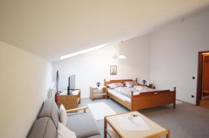 ein Schlafzimmer mit einem Bett und einem Sofa in der Unterkunft Gschwendtnerhof in Aschau im Chiemgau