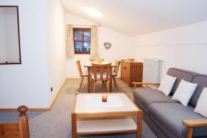 ein Wohnzimmer mit einem Sofa und einem Tisch in der Unterkunft Gschwendtnerhof in Aschau im Chiemgau