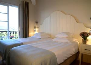 A bed or beds in a room at Hôtel Eze Hermitage entre Nice et Monaco