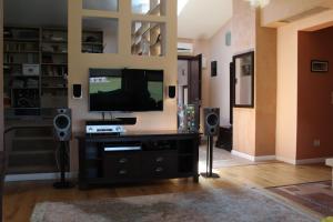 a living room with a flat screen tv and speakers at Vila Ramona in Otopeni