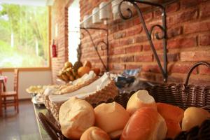 a table topped with baskets of bread and other foods at Pousada Primaz de Minas in Mariana