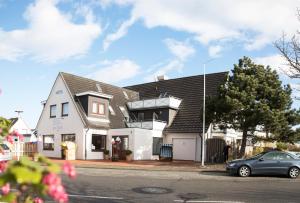 a house with a car parked in front of it at Hotel Jess am Meer in Büsum