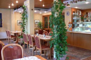 a restaurant with a table and chairs and plants at Hotel Quellenhof in Bad Breisig