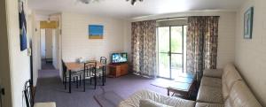 a living room with a couch and a table at Aquarius Holiday Apartments in Batemans Bay