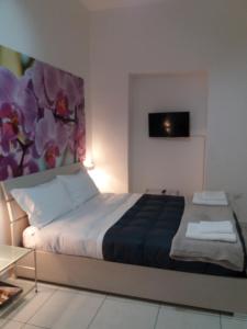 1 dormitorio con 1 cama con una pintura en la pared en Depandance Machiavelli, en Cagliari