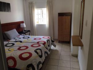 a small bedroom with a bed and a window at The Crescent Guesthouses - BnB/Self Catering in Durban