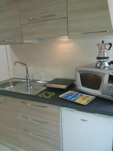 a kitchen with a sink and a microwave on a counter at Depandance Machiavelli in Cagliari