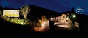 nocny widok na ulicę z budynkiem z oświetleniem w obiekcie Wine & Art Relais Vallombrosa w mieście Castelrotto