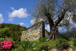 a sign on the side of a stone building with a tree at Wine & Art Relais Vallombrosa in Castelrotto