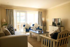 una sala de estar con un sofá y una mesa en Quarterdeck 17, en St Francis Bay