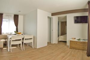 1 dormitorio y sala de estar con mesa y sillas. en Holiday Mobile Homes Park Riviera, en Novigrad Istria