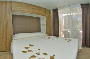 a bedroom with a bed with leaves on it at Holiday Mobile Homes Park Riviera in Novigrad Istria