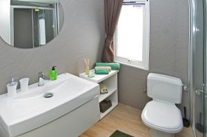 een badkamer met een witte wastafel en een spiegel bij Holiday Mobile Homes Park Riviera in Novigrad Istria