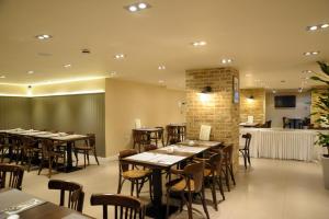 a restaurant with tables and chairs in a room at Kings Cross Inn Hotel in London