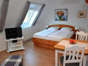 a bedroom with a bed and a table with a television at Haus Seeflieger in Westerland
