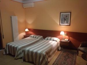 ein Hotelzimmer mit zwei Betten und zwei Lampen in der Unterkunft Hotel Due Fontane in Casalpusterlengo