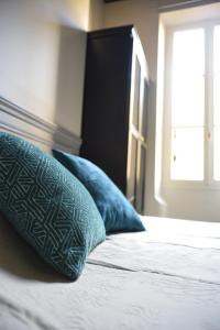 a bed with two blue pillows on top of it at Cosy apartment ideally located in the Old Town in Lyon