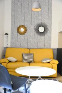 a yellow couch and a table in a room at Cosy apartment ideally located in the Old Town in Lyon